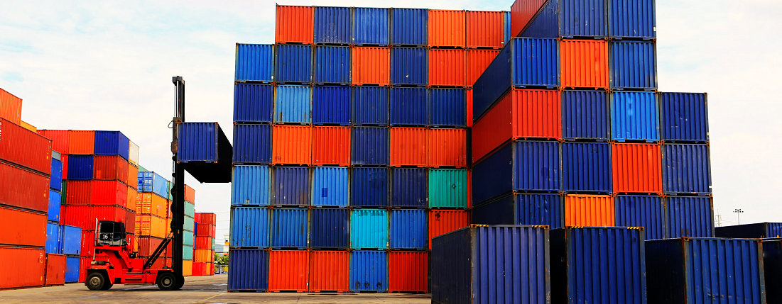 forklift lifting a blue container at the docks